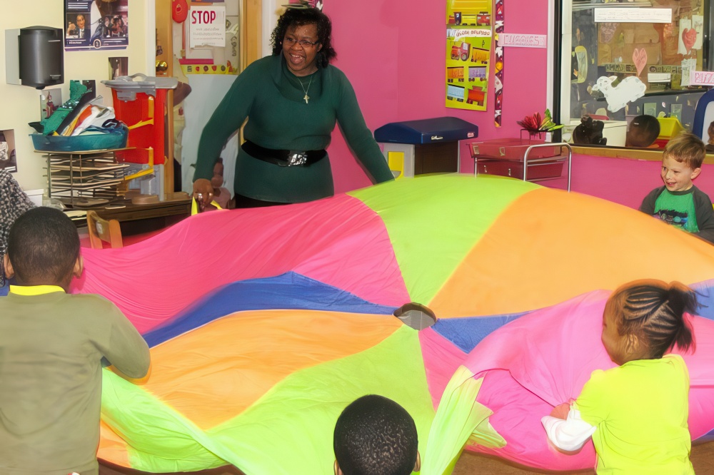 Teacher interacting with children in a nurturing classroom environment, everybody is having fun.