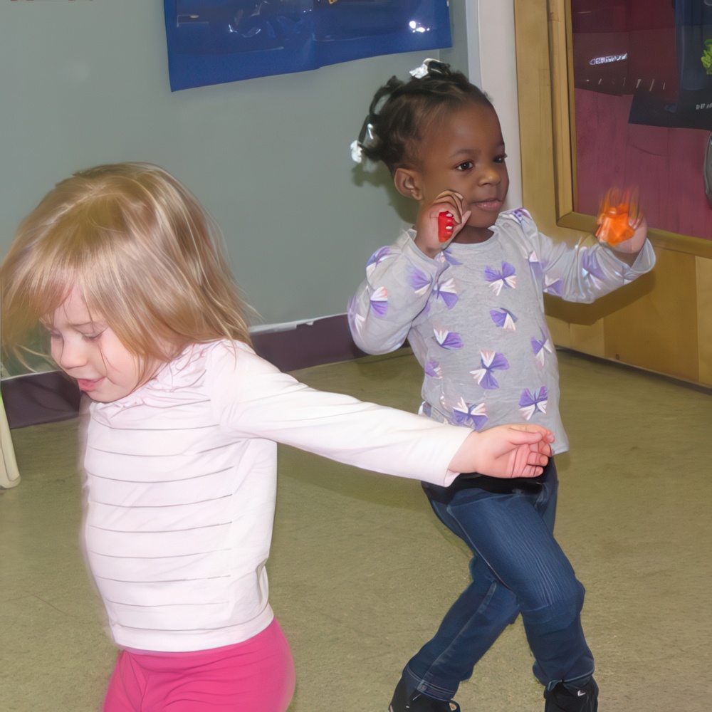 Two joyful children play together, one holding a toy, both enjoying their carefree moment of fun.