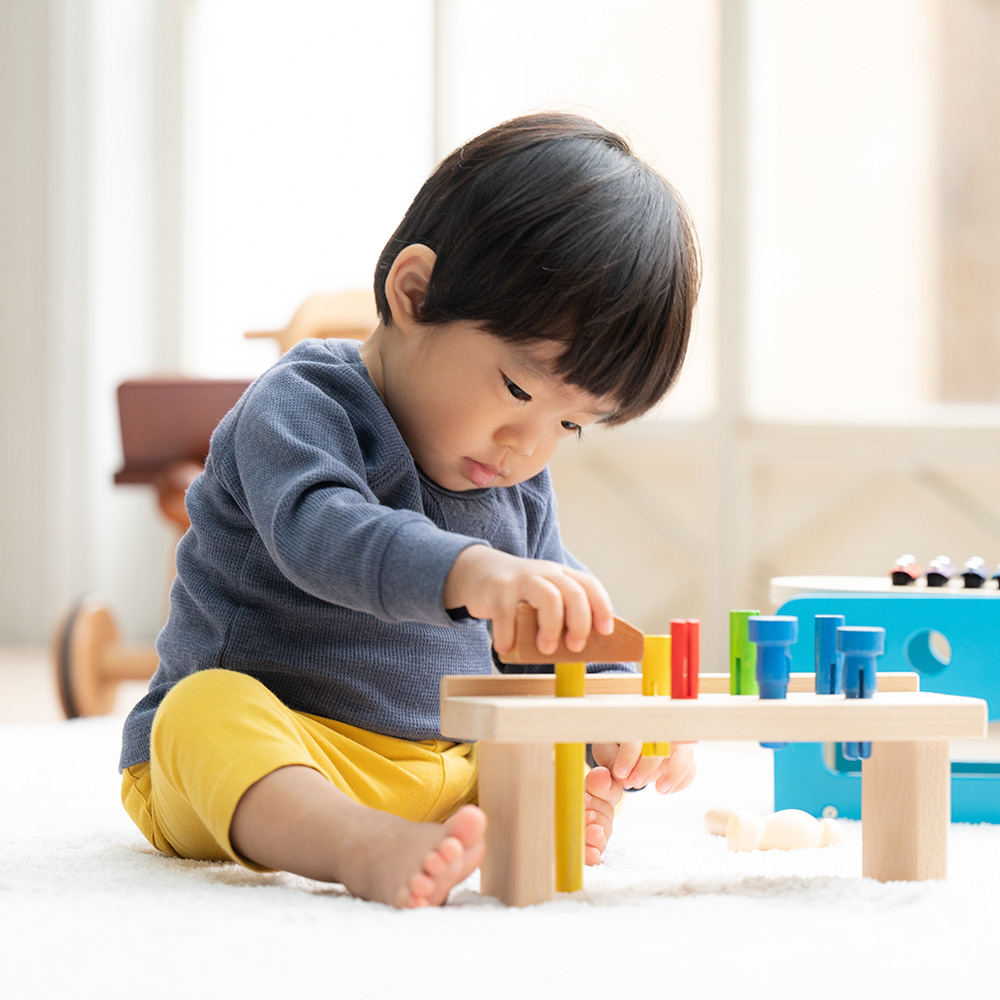 A focused child plays with colorful blocks, concentrating on their activity with intent.